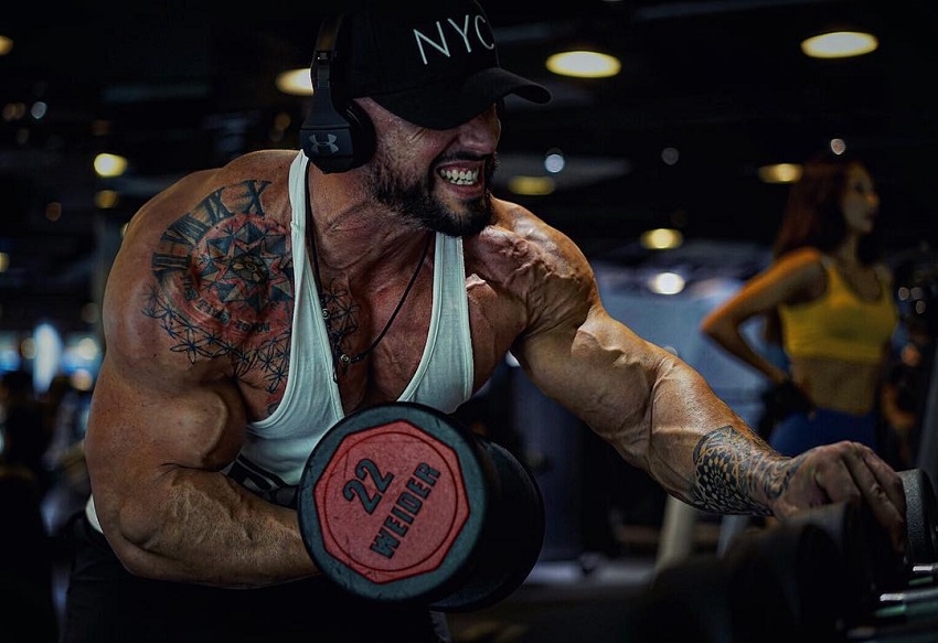 Benjamin Radic doing intense bicep curls with a pained grimace