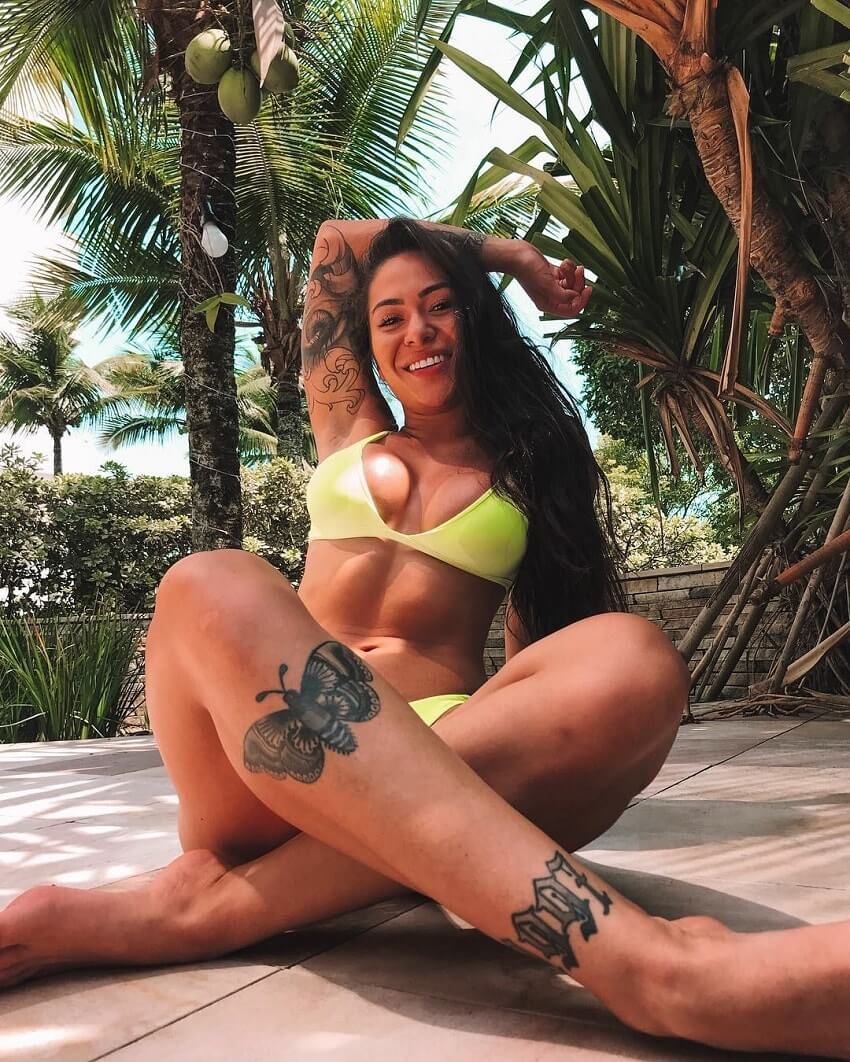 Paola Matoso posing in a yellow swimsuit looking fit and healthy